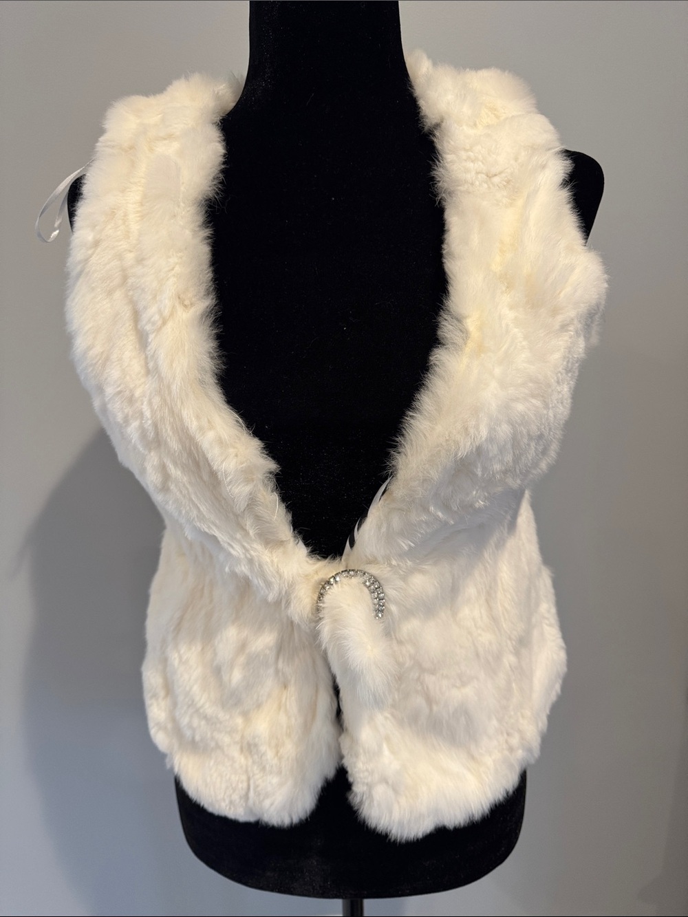 White faux fur vest size small. Rhinestone buckle closure.